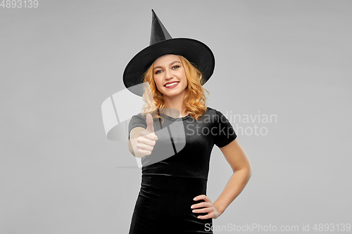 Image of happy woman in black halloween costume of witch