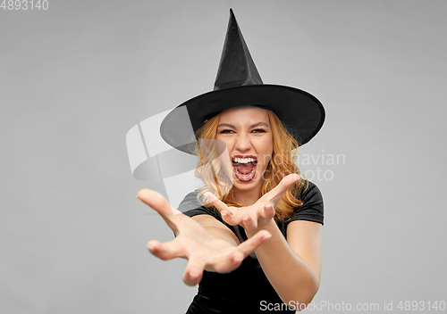 Image of scary woman in black halloween costume of witch