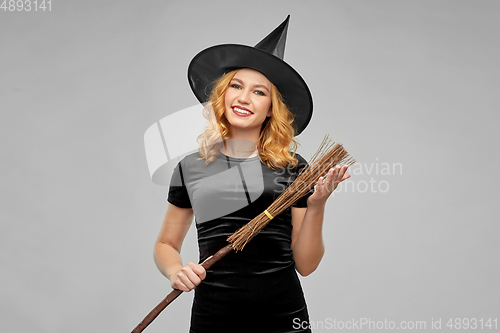 Image of woman in halloween costume of witch with broom