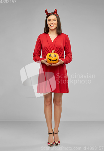 Image of woman in halloween costume of devil with pumpkin