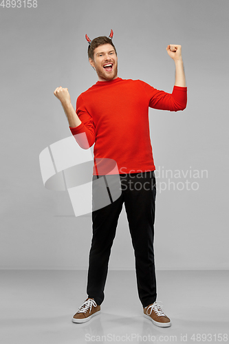 Image of happy man in costume of devil celebrating success