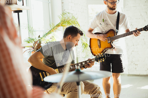 Image of Musician band jamming together in art workplace with instruments