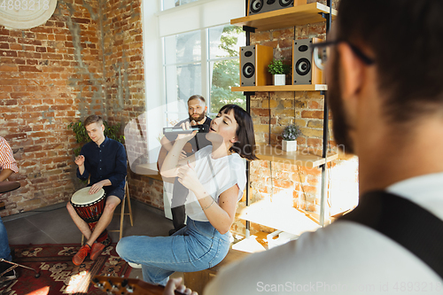 Image of Musician band jamming together in art workplace with instruments