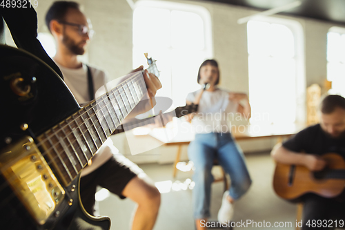 Image of Musician band jamming together in art workplace with instruments