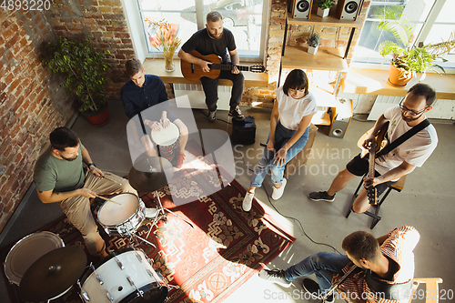 Image of Musician band jamming together in art workplace with instruments