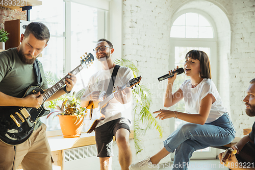 Image of Musician band jamming together in art workplace with instruments