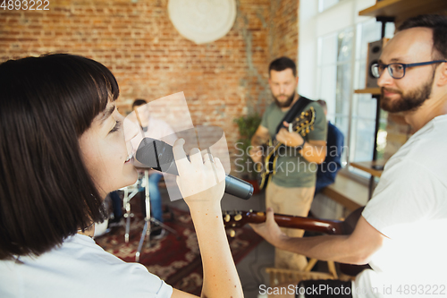 Image of Musician band jamming together in art workplace with instruments