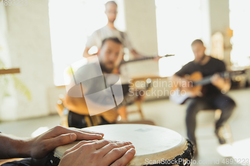 Image of Musician band jamming together in art workplace with instruments