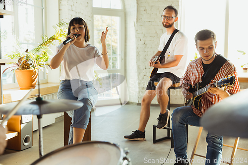 Image of Musician band jamming together in art workplace with instruments