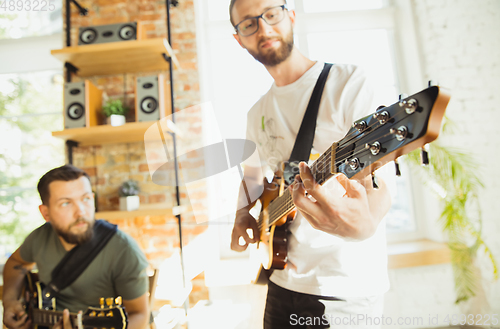 Image of Musician band jamming together in art workplace with instruments