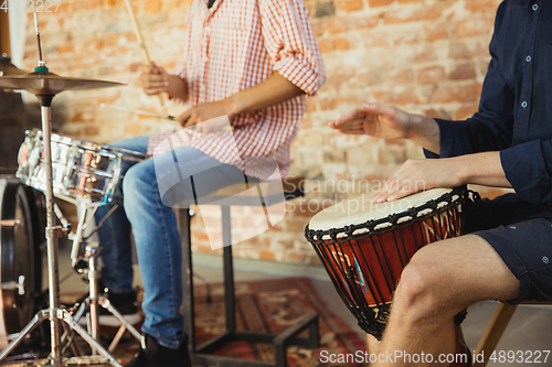 Image of Musician band jamming together in art workplace with instruments