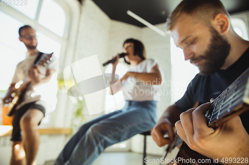 Image of Musician band jamming together in art workplace with instruments