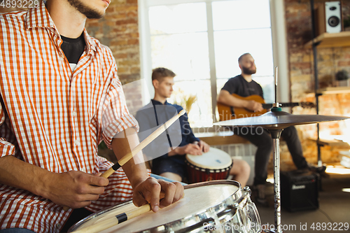 Image of Musician band jamming together in art workplace with instruments