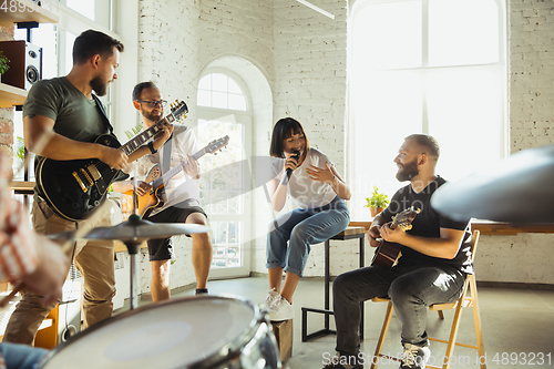 Image of Musician band jamming together in art workplace with instruments