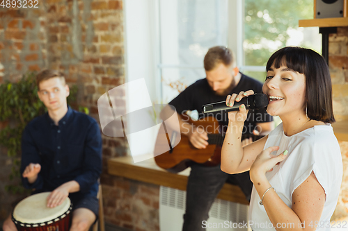 Image of Musician band jamming together in art workplace with instruments