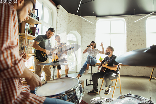 Image of Musician band jamming together in art workplace with instruments