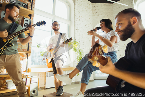 Image of Musician band jamming together in art workplace with instruments