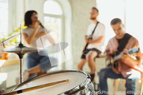 Image of Musician band jamming together in art workplace with instruments