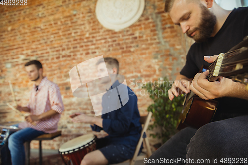 Image of Musician band jamming together in art workplace with instruments