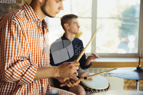 Image of Musician band jamming together in art workplace with instruments