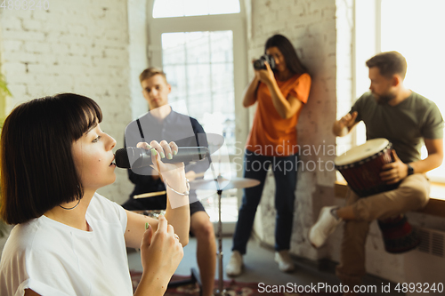 Image of Musician band jamming together in art workplace with instruments