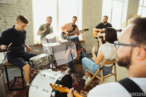 Image of Musician band jamming together in art workplace with instruments