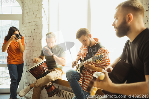 Image of Musician band jamming together in art workplace with instruments