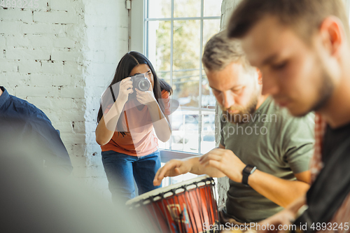 Image of Musician band jamming together in art workplace with instruments