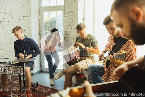 Image of Musician band jamming together in art workplace with instruments