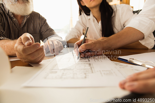 Image of Male architect-engineer presents project of future house for young family.