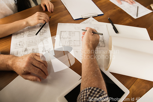 Image of Male architect-engineer presents project of future house for young family.