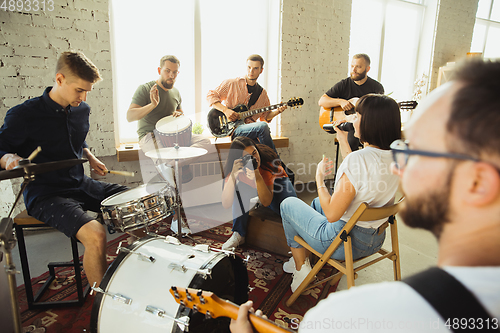 Image of Musician band jamming together in art workplace with instruments