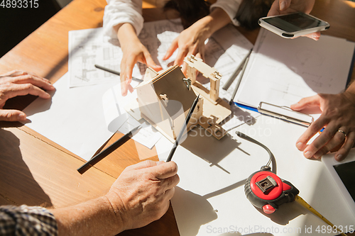 Image of Male architect-engineer presents project of future house for young family.