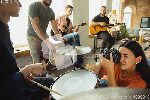 Image of Musician band jamming together in art workplace with instruments