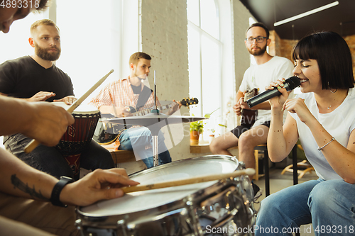 Image of Musician band jamming together in art workplace with instruments