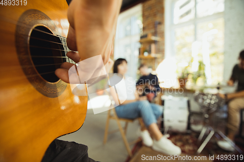 Image of Musician band jamming together in art workplace with instruments