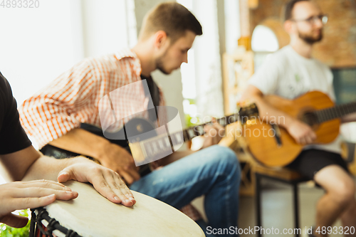 Image of Musician band jamming together in art workplace with instruments