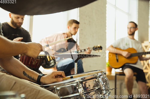 Image of Musician band jamming together in art workplace with instruments