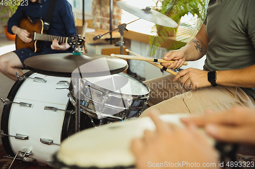 Image of Musician band jamming together in art workplace with instruments