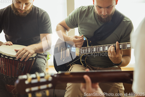 Image of Musician band jamming together in art workplace with instruments