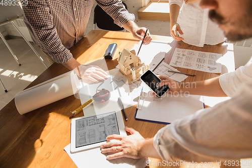 Image of Male architect-engineer presents project of future house for young family.