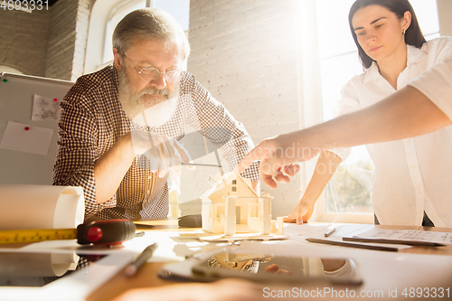 Image of Male architect-engineer presents project of future house for young family.