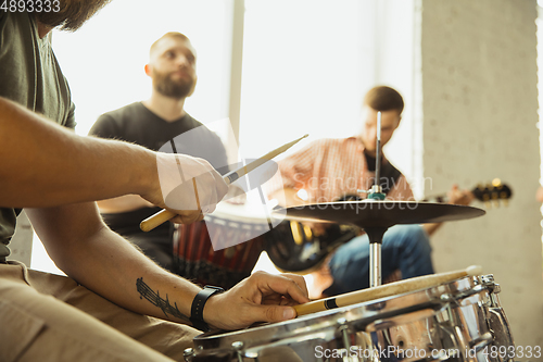 Image of Musician band jamming together in art workplace with instruments