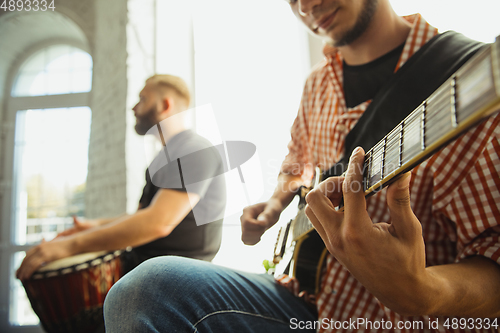 Image of Musician band jamming together in art workplace with instruments