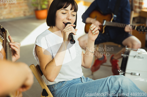 Image of Musician band jamming together in art workplace with instruments