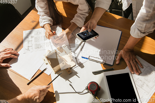 Image of Male architect-engineer presents project of future house for young family.