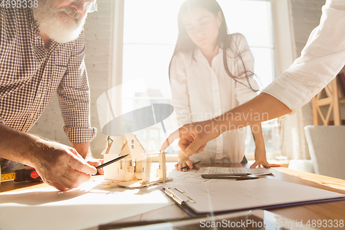 Image of Male architect-engineer presents project of future house for young family.