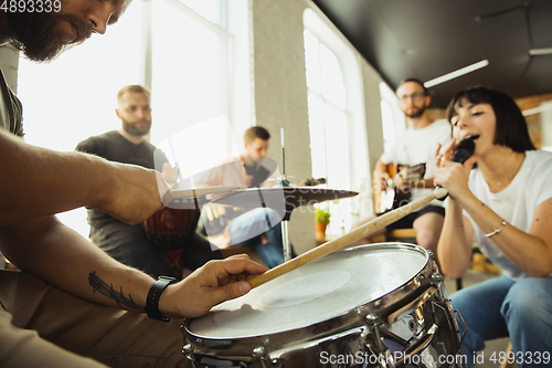 Image of Musician band jamming together in art workplace with instruments