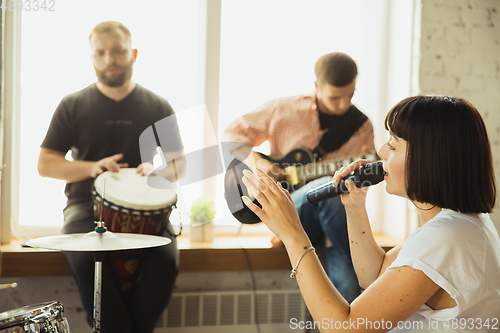 Image of Musician band jamming together in art workplace with instruments