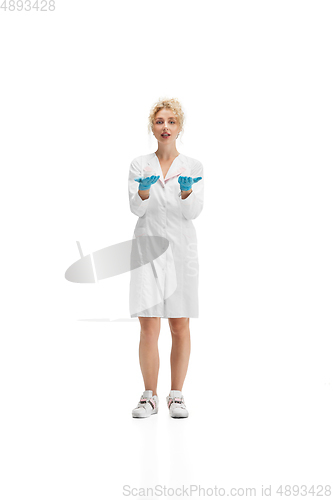 Image of Portrait of female doctor, nurse or cosmetologist in white uniform and blue gloves over white background